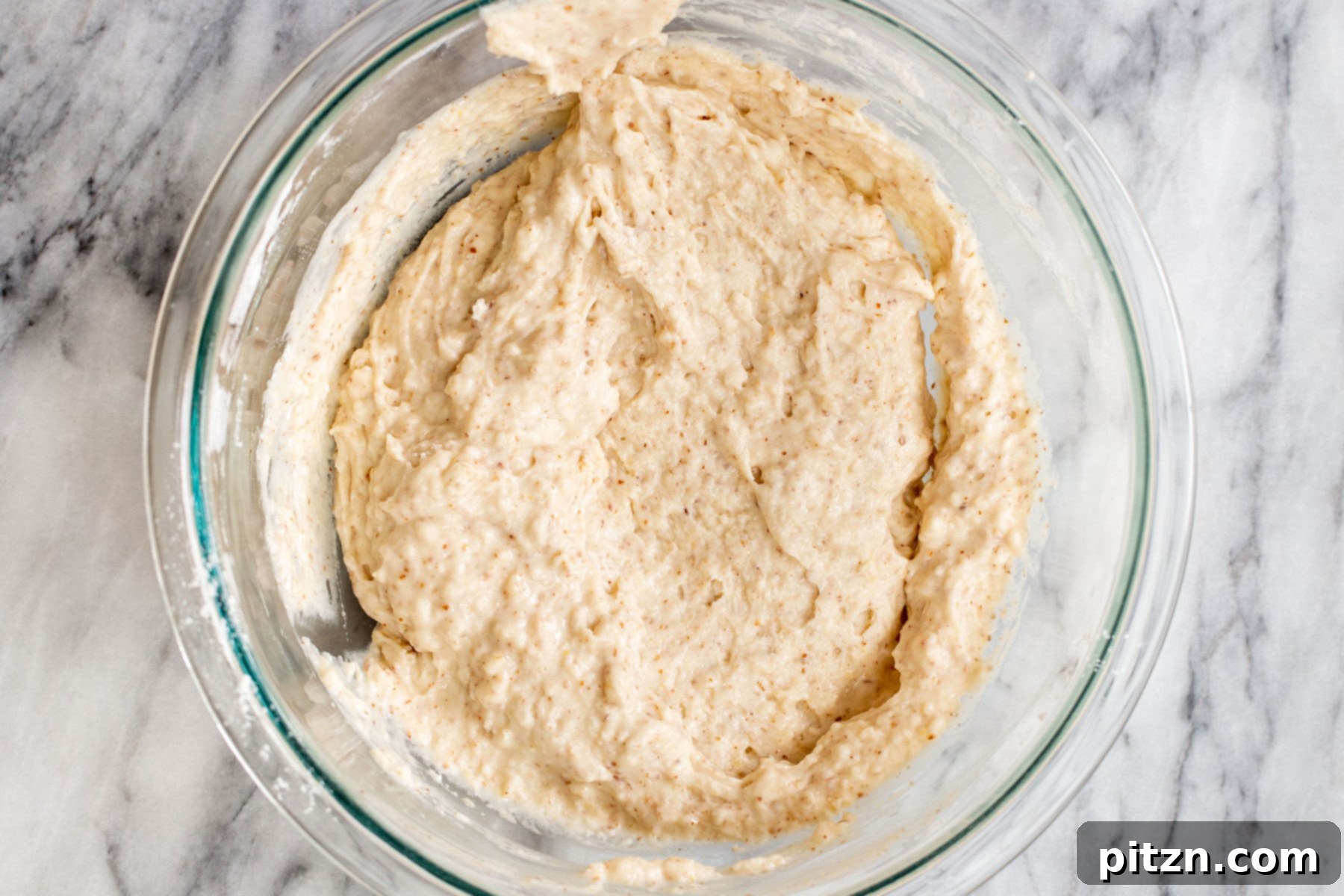 Plant-Based Boston Dream Cake 11 The vegan cake batter in a glass bowl, now fully mixed to a smooth, consistent texture after combining wet and dry ingredients.