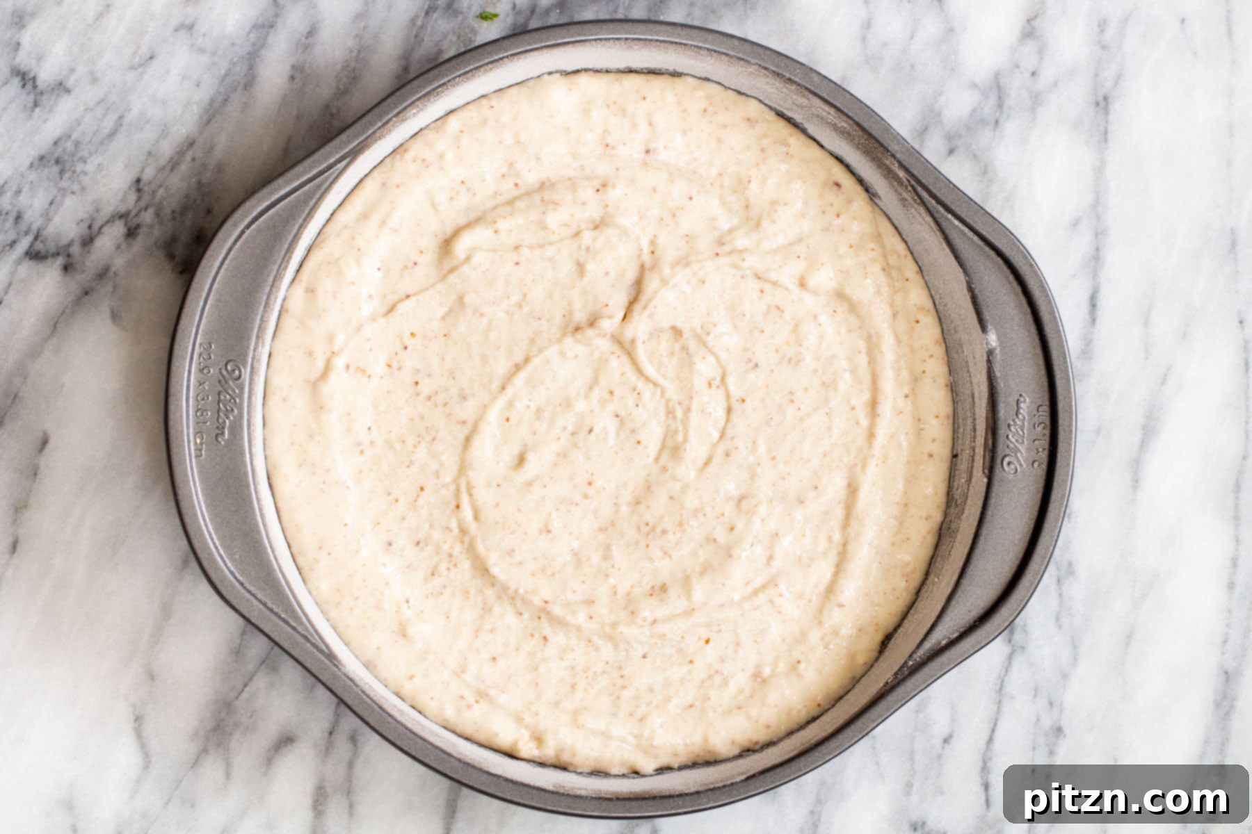 Plant-Based Boston Dream Cake 12 Vegan cake batter neatly poured into a greased springform pan lined with parchment paper, ready for baking.