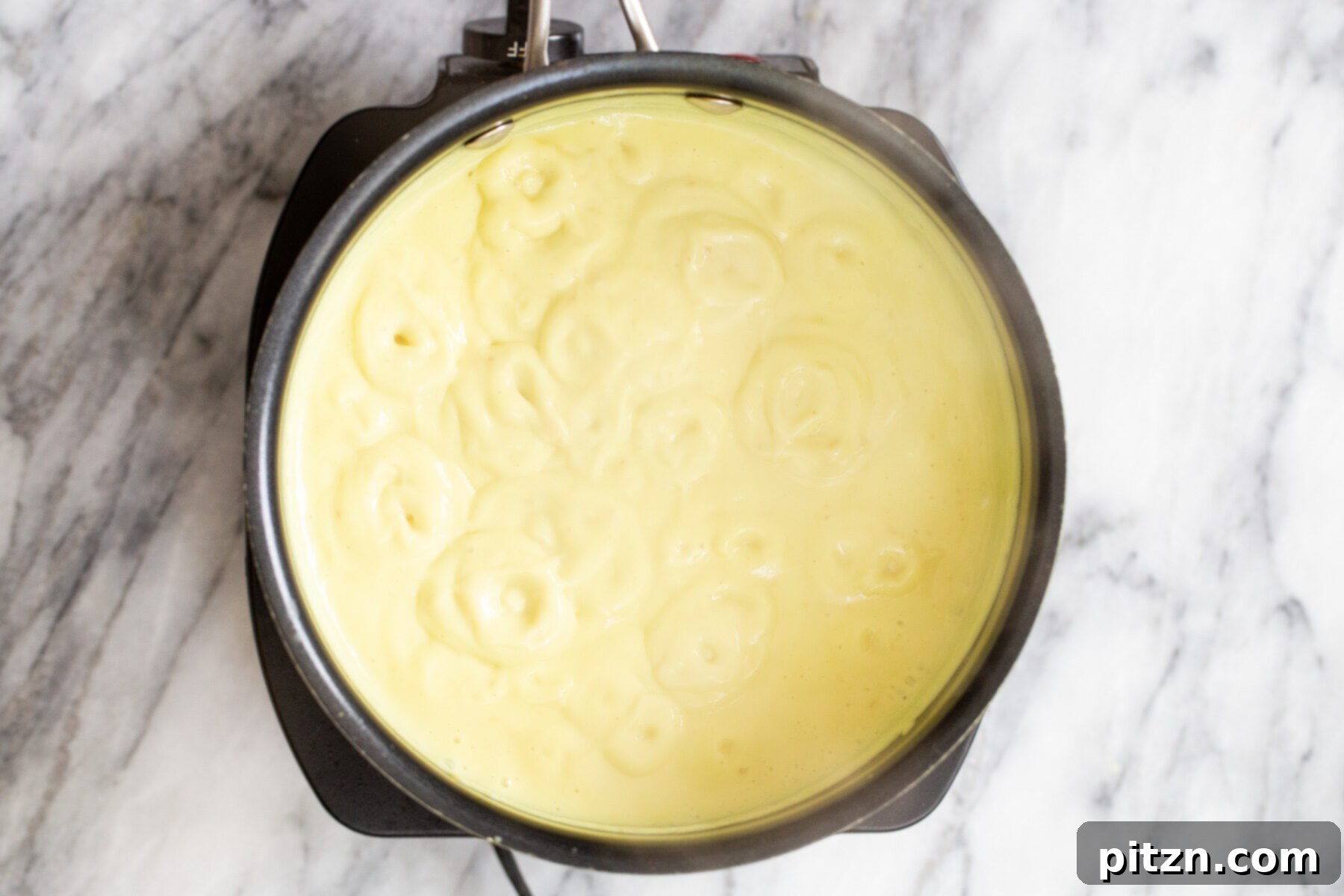 Plant-Based Boston Dream Cake 18 Thickened vegan vanilla custard in a saucepan, showing its creamy and smooth consistency after being cooked on the stovetop.