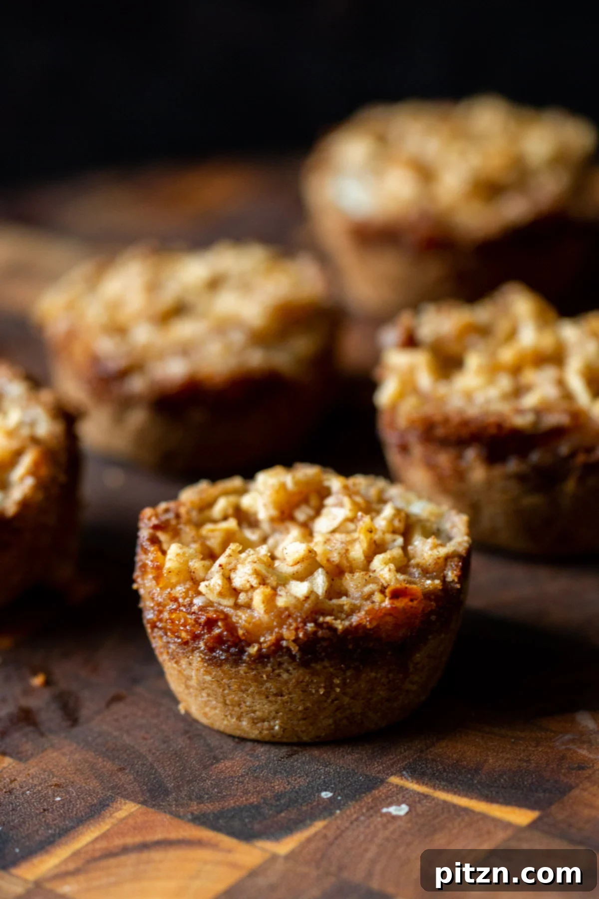 Mini Apple Pie Cheesecake Delights 2 Side view of elegantly arranged vegan mini apple pie cheesecakes on a rustic wooden board, ready to be served