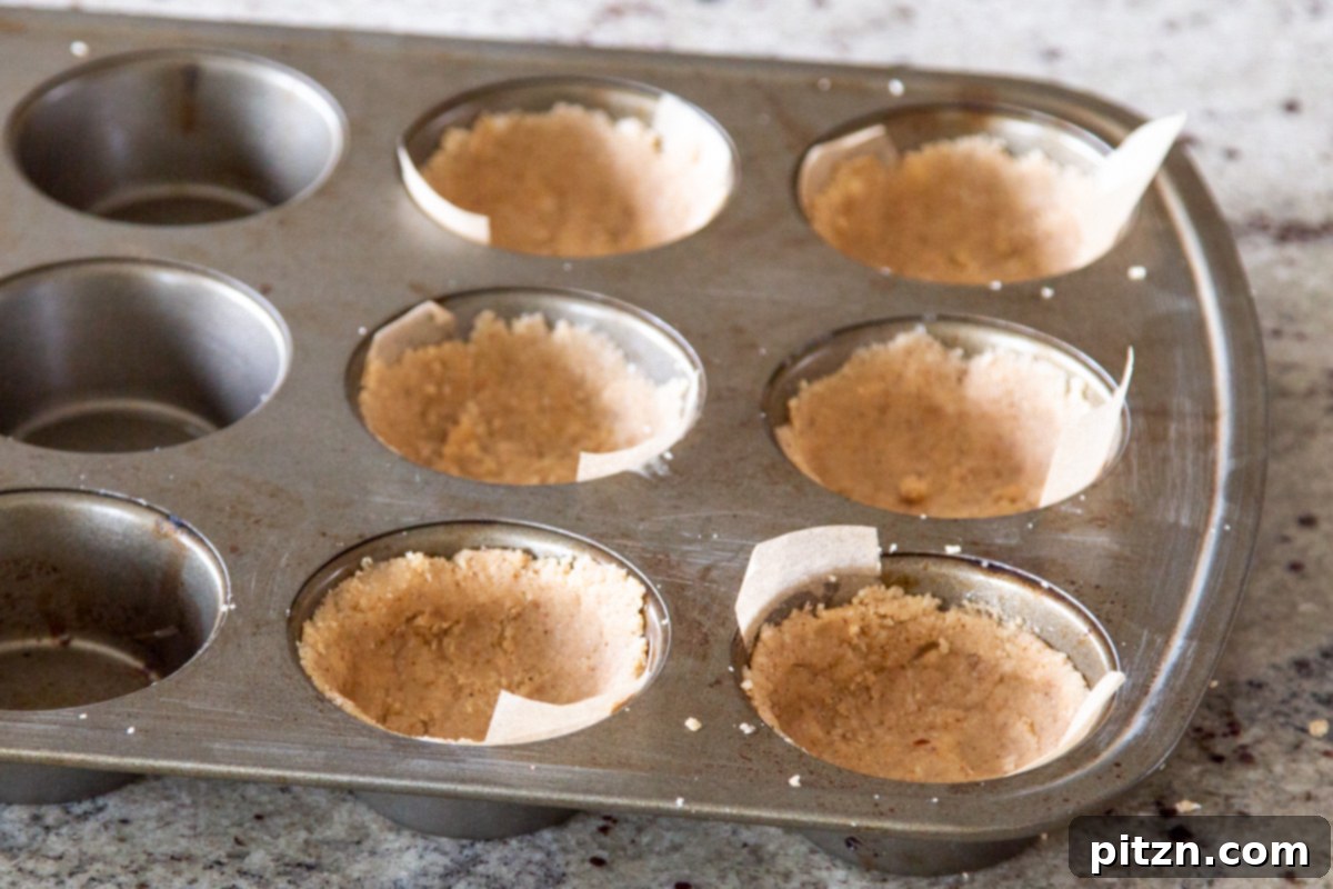 Mini Apple Pie Cheesecake Delights 10 A muffin tin is prepared with parchment paper strips, ready for the vegan tart crusts