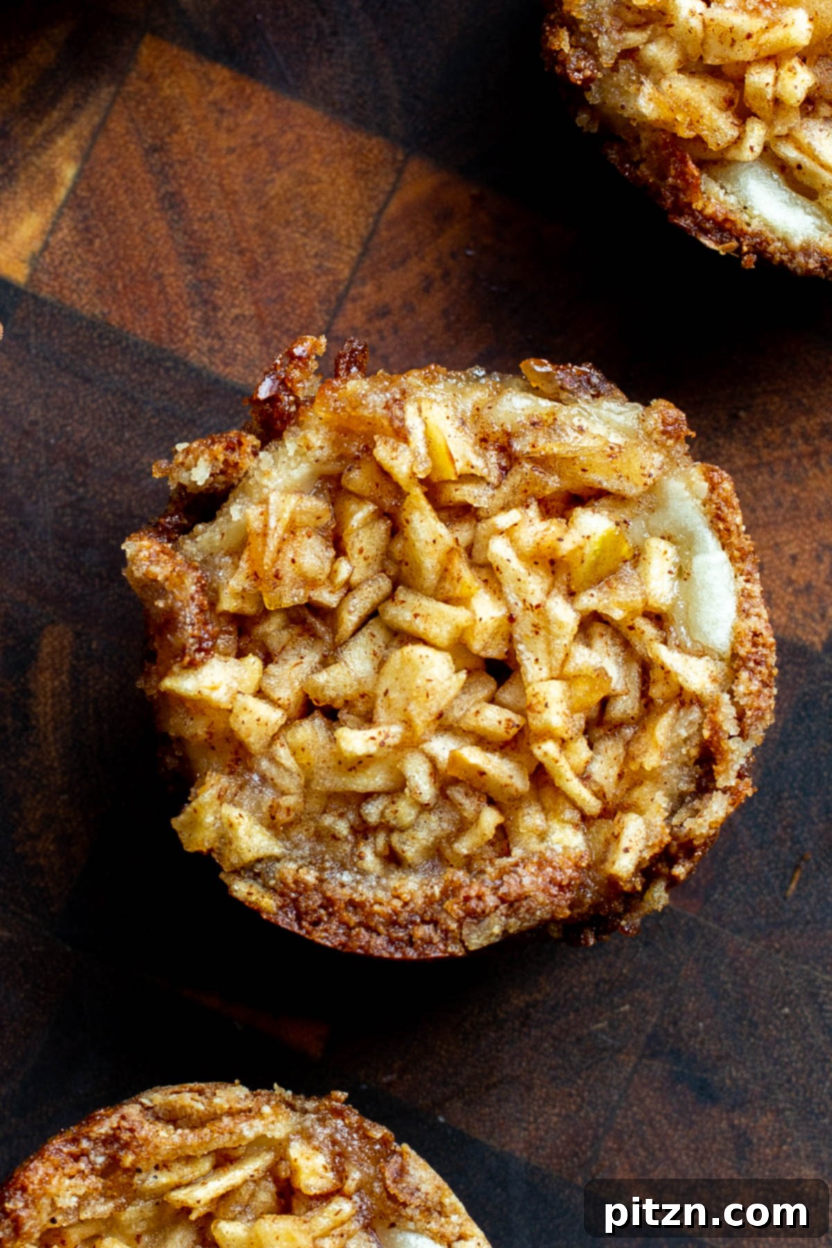 Mini Apple Pie Cheesecake Delights 17 An inviting overhead shot of delicious mini vegan apple pies arranged artfully on a wooden board