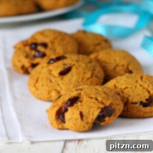 Delicious Vegan Carrot, Almond & Cranberry Muffin Top Cookies 2 Six muffin top cookies on a white fabric with a blue ribbon, highlighting their delicious appearance.