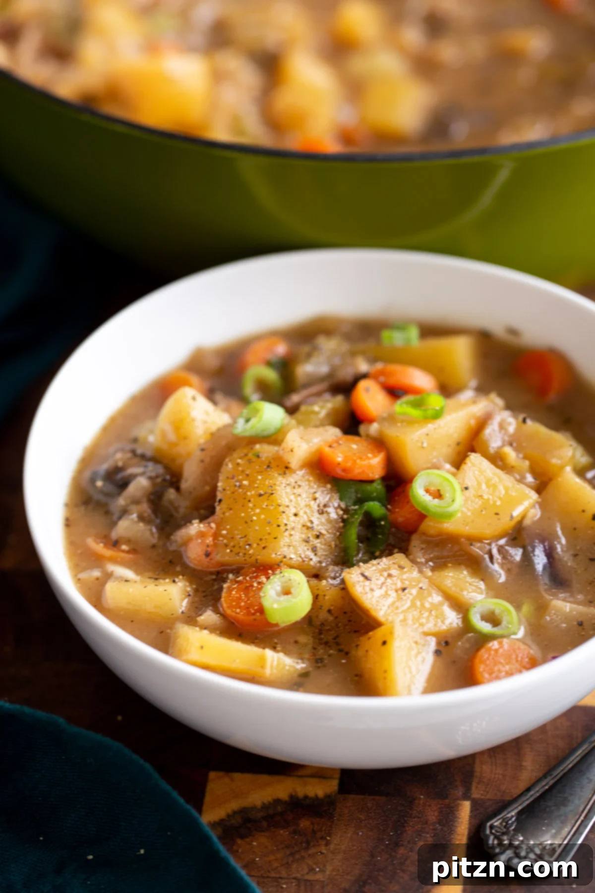 A generously filled bowl of comforting vegan Irish stew, featuring tender potatoes, carrots, mushrooms, and a rich, savory broth.