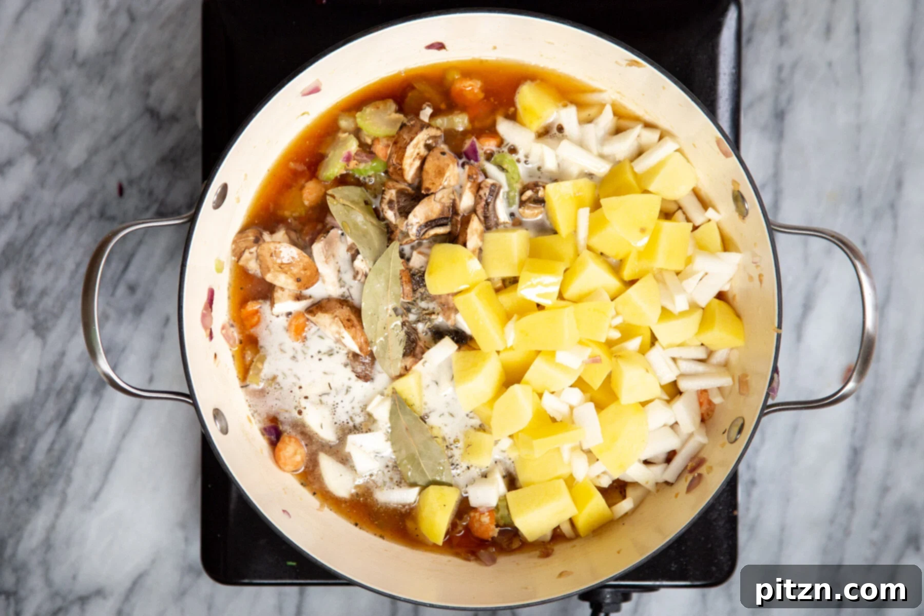 Various stew ingredients, including potatoes and mushrooms, being added to a pot to create the vegan Irish stew.
