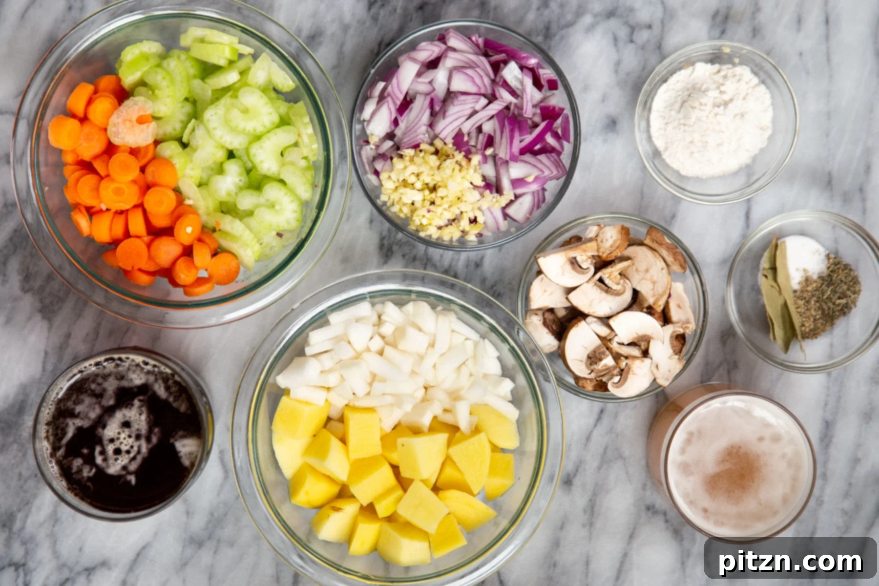 Assorted fresh ingredients for making vegan Irish stew laid out on a marble countertop, including vegetables, herbs, and seasonings.