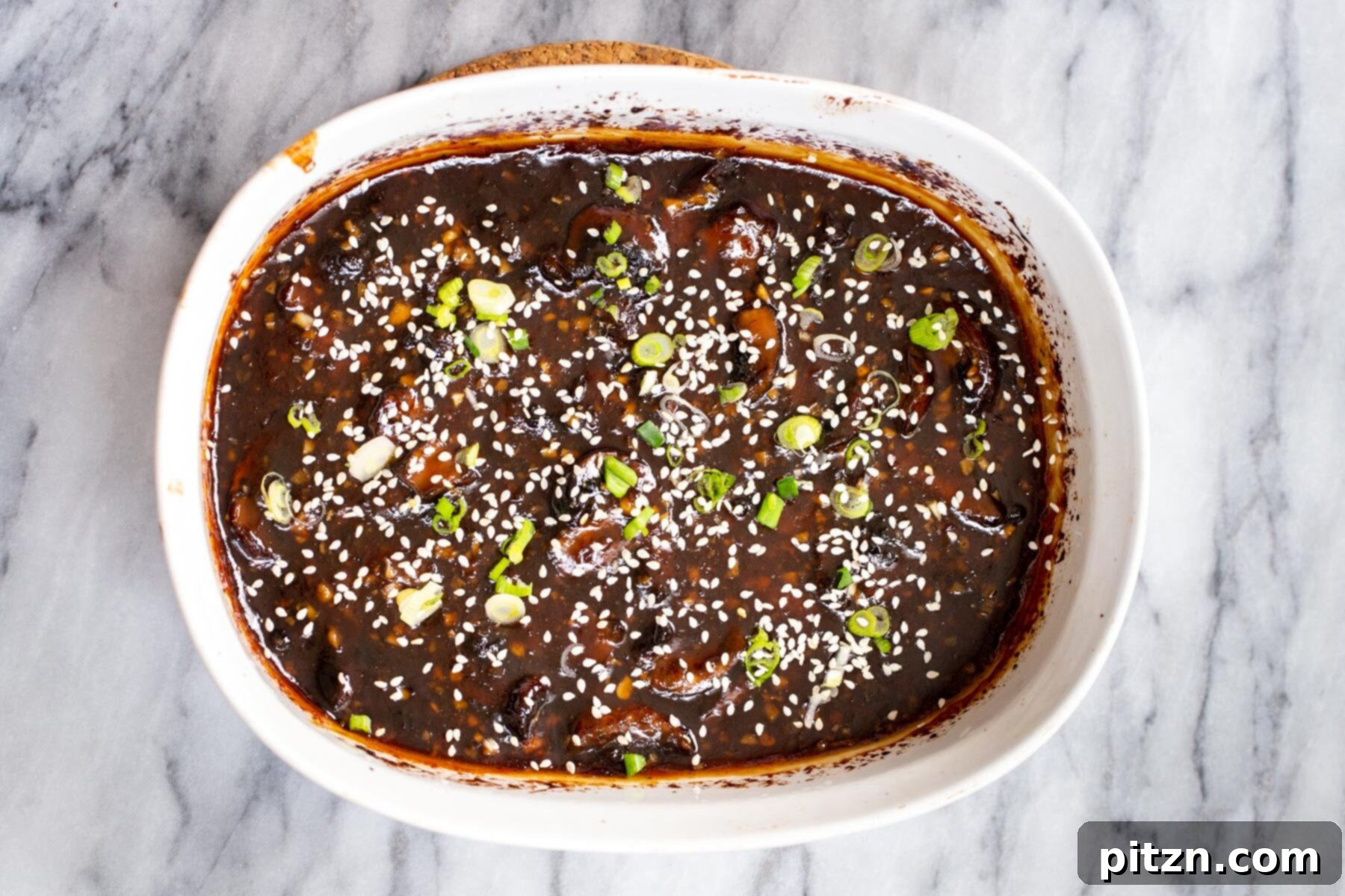 Sesame Glazed Mushrooms 14 Sticky sesame mushrooms in a casserole dish sprinkled with sesame seeds and green onions