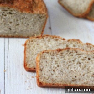 Pear Quinoa Chai Spice Bread loaf with slices cut on a white wooden background.