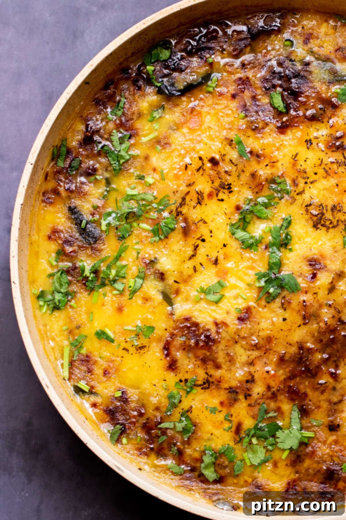 Caramelized Onion Lentil Stew 19 A frying pan filled with creamy dal, garnished generously with freshly chopped cilantro, ready to be served and enjoyed as a comforting and aromatic dish.
