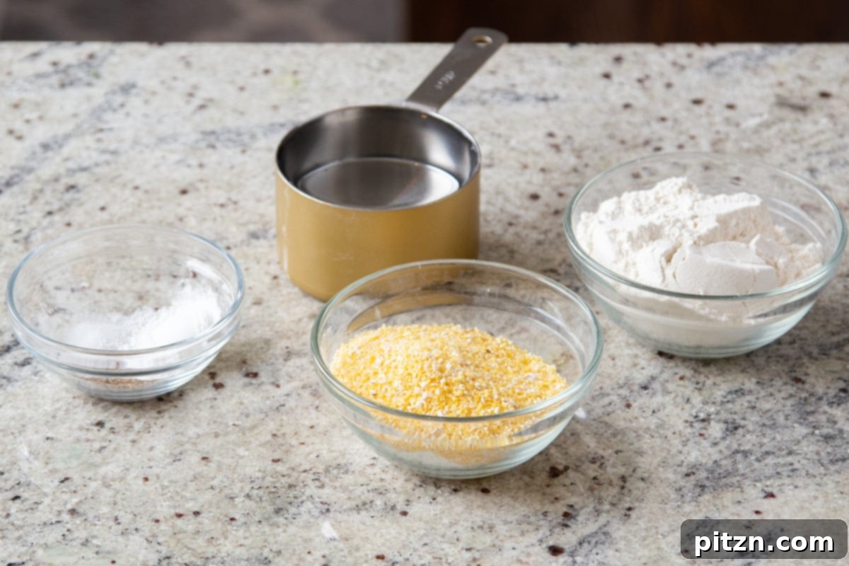 Ingredients for the cornbread topping for Saag Cornbread Casserole, including cornmeal, flour, and various spices in small bowls.