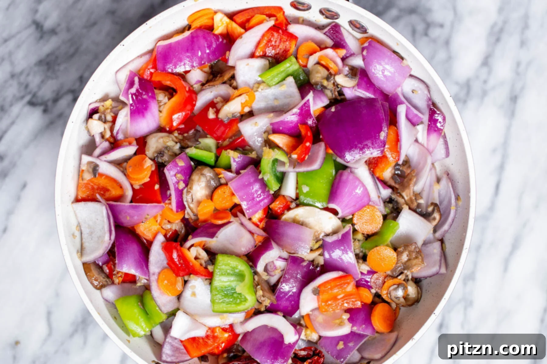 Blazing Garlic Vegetable Medley 10 A vibrant mix of chopped veggies continuing to fry in a pan, achieving perfect crisp-tenderness before the sauce is added.
