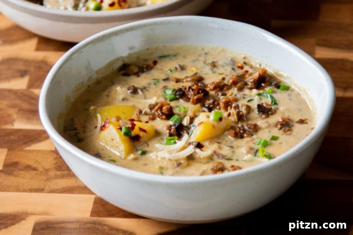 A finished bowl of vegan Zuppa Toscana, topped with savory veggie crumbles and ready to be enjoyed.