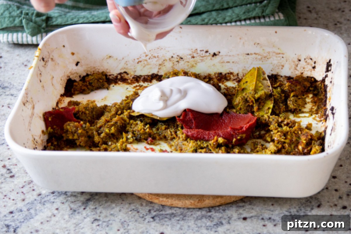 Vegan Lentil Keema Pav Bake 13 adding non-dairy yogurt and tomato paste to the cooked aromatics