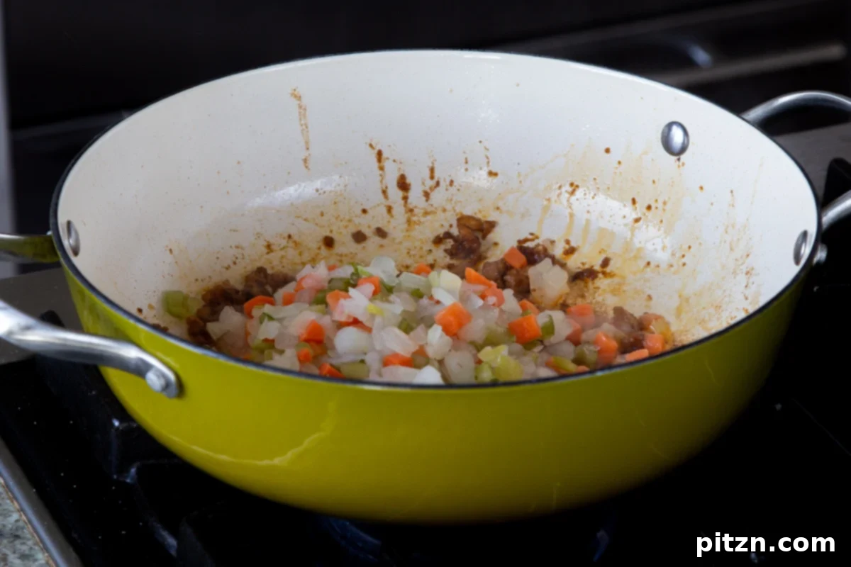 Fireside Smoked Potato Soup 9 Adding chopped onion, celery, carrots, and bay leaves to a pan with a small amount of oil for the soup base