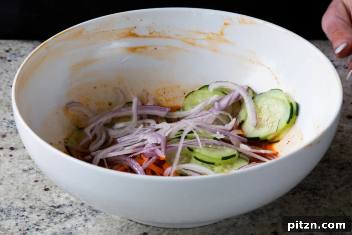 Spicy Gochujang Tofu Sandwich 13 Onions added with cucumbers and carrots to the marinade, before mixing.