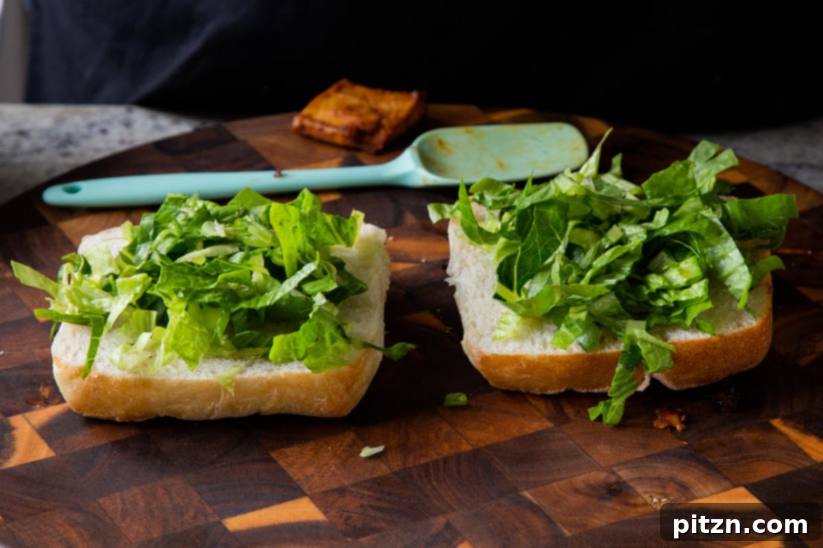 Spicy Gochujang Tofu Sandwich 15 Ciabatta rolls with lettuce on them, forming the base of the sandwich.