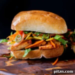 Gochujang tofu banh mi with pickled veggies on a wooden cutting board