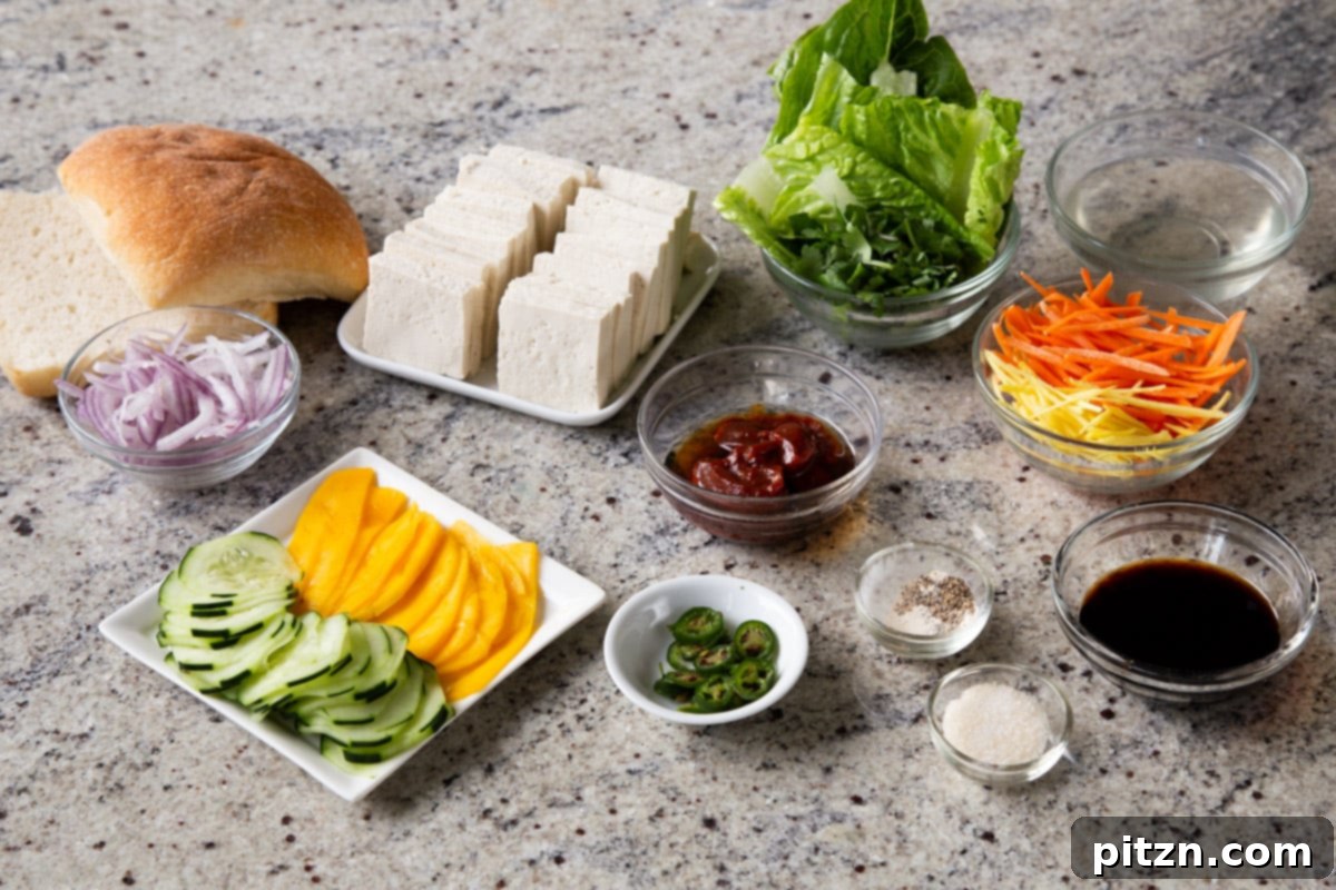 Spicy Gochujang Tofu Sandwich 6 Assortment of tofu, fresh vegetables, gochujang, and other sandwich ingredients laid out on a marble table.