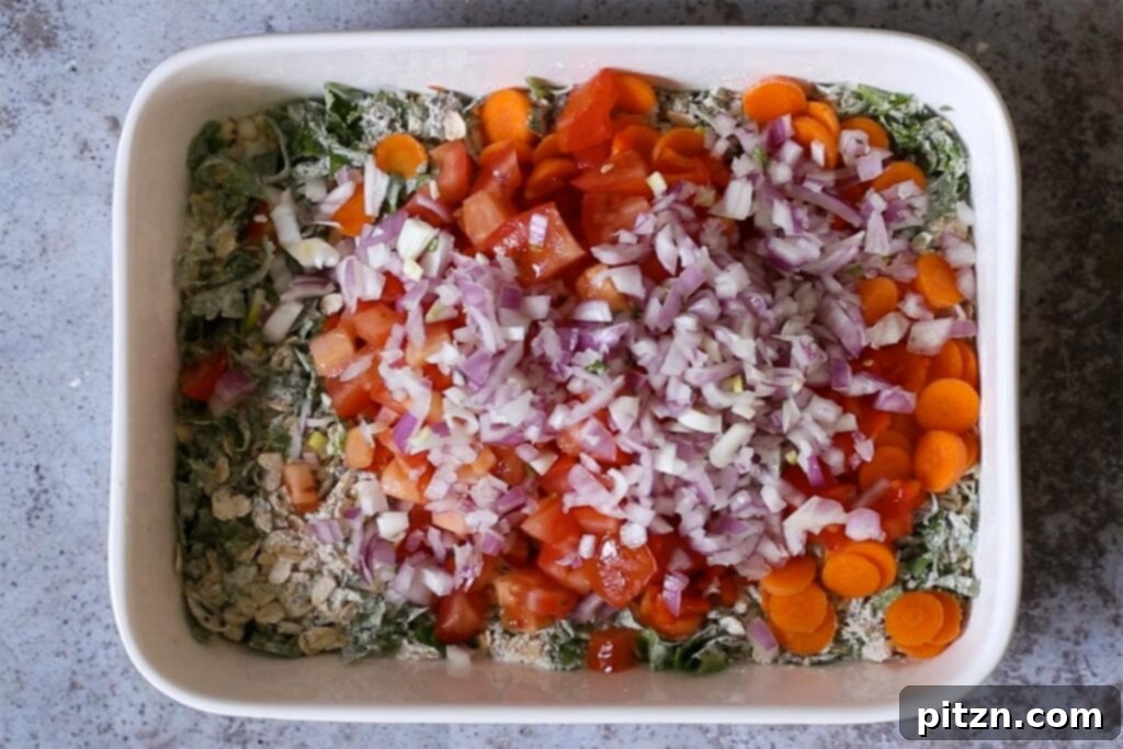 Vegan Savory Vegetable Baked Oats 9 adding a generous amount of colorful chopped veggies to the savory oats mixture in the pan