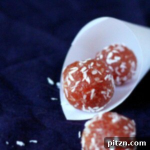 Pink coconut balls in a paper funnel on a dark background