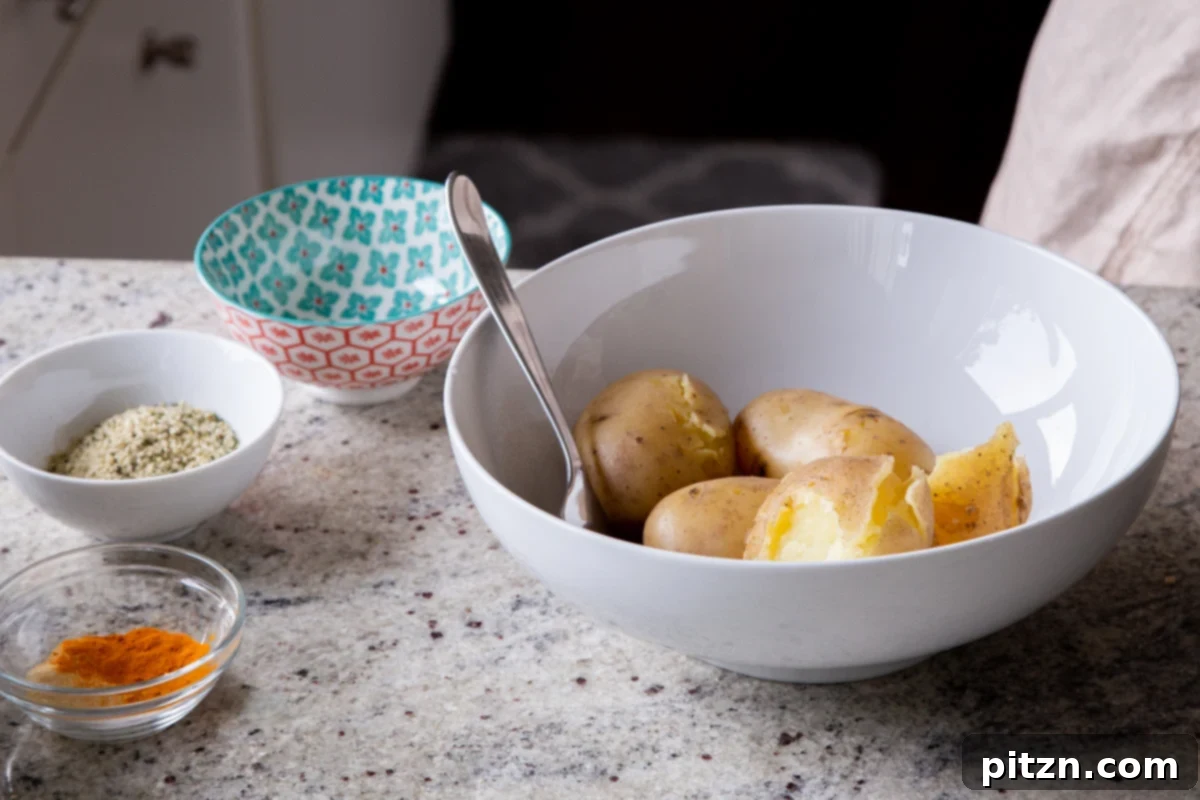 A bowl filled with tender, cooked potatoes, perfectly soft and ready for mashing to become the delicious filling.