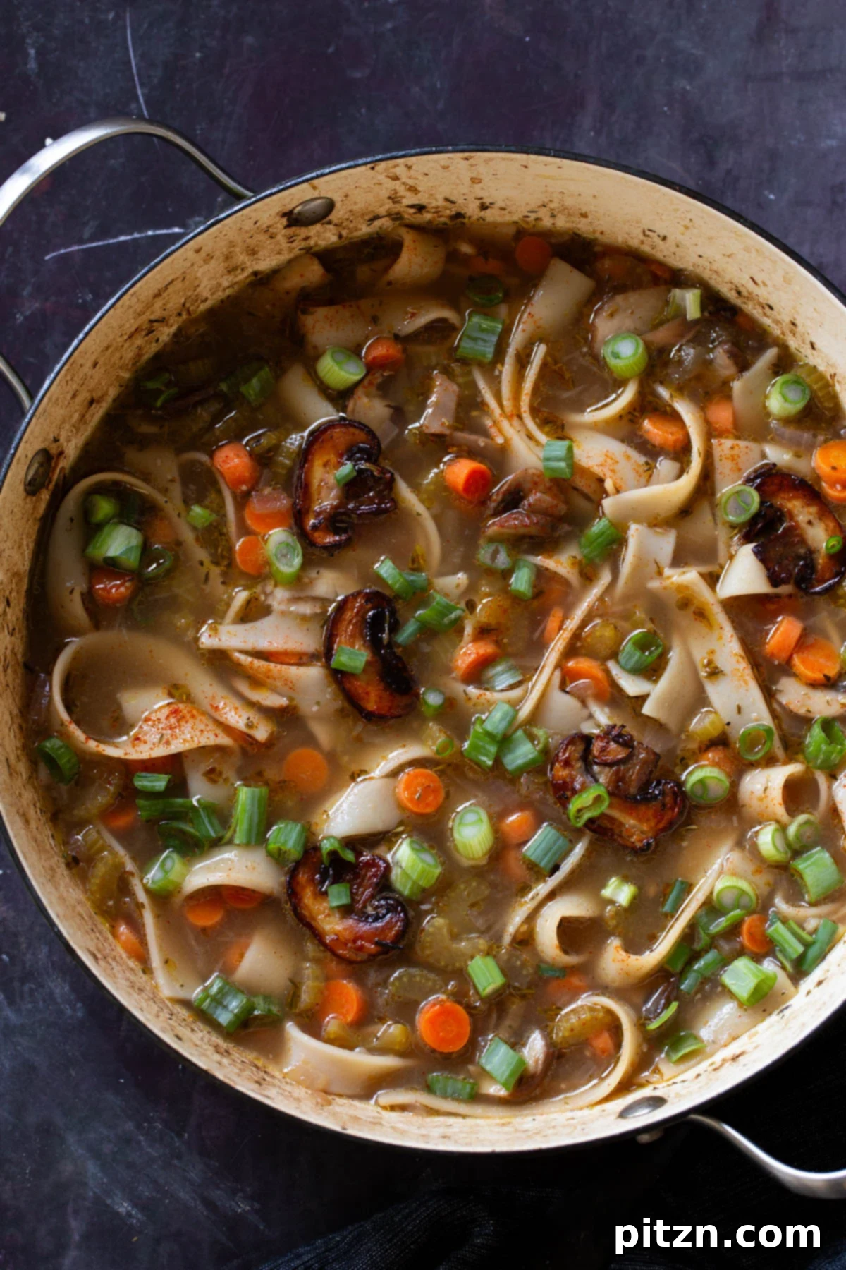 Hearty One-Pot Mushroom Noodle Delight 2 A steaming bowl of comforting mushroom noodle soup, showcasing wide rice noodles and sliced mushrooms.