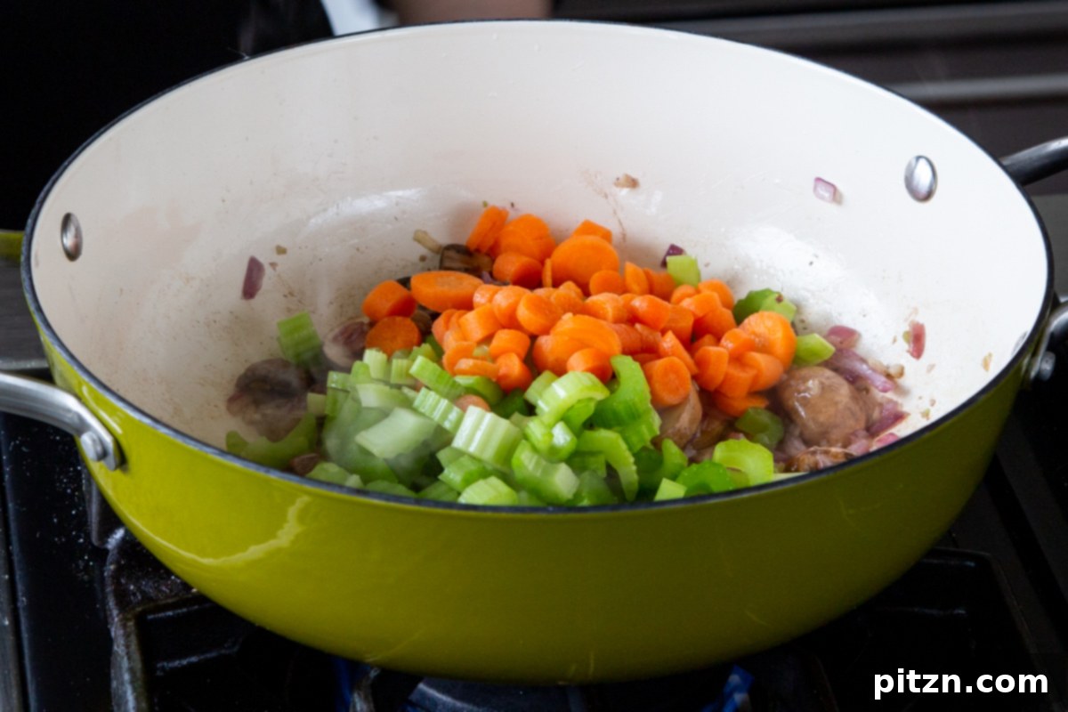 Hearty One-Pot Mushroom Noodle Delight 11 Carrots and celery being added to the pan of cooked mushrooms, onion, and garlic.