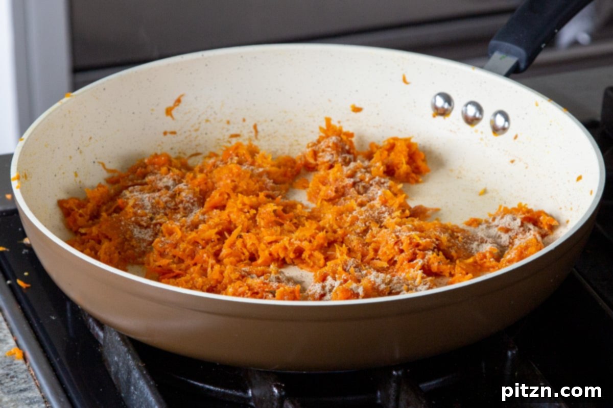 Decadent Carrot Halwa Gateau 13 Shredded carrots after cooking with maple syrup, almond flour, cardamom, and lime zest, showcasing their caramelized texture.