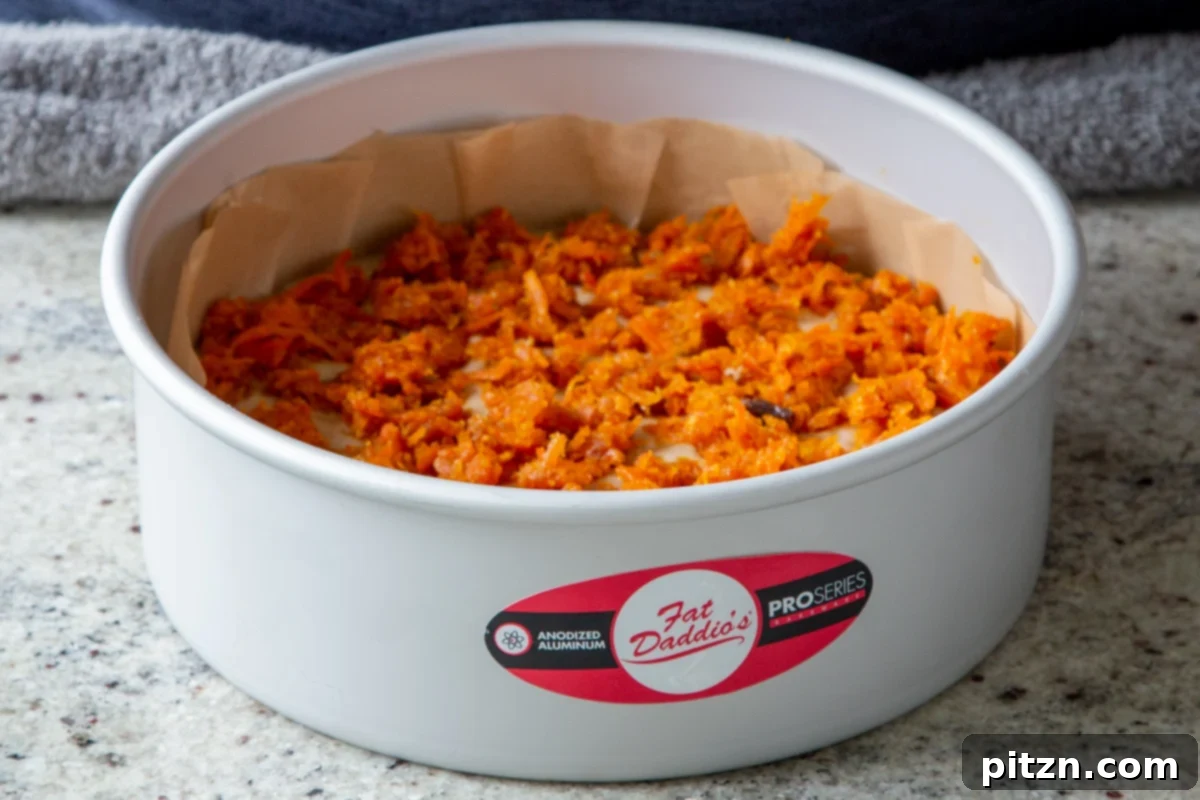 Decadent Carrot Halwa Gateau 26 Cake batter topped with the remaining carrot halwa mixture, creating a rich and flavorful layer.