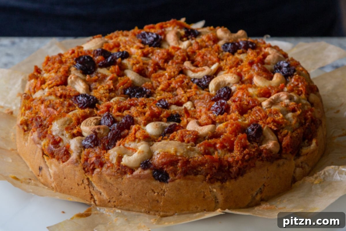 Decadent Carrot Halwa Gateau 29 Vegan carrot halwa cake resting on parchment paper after baking and initial cooling, ready for slicing.