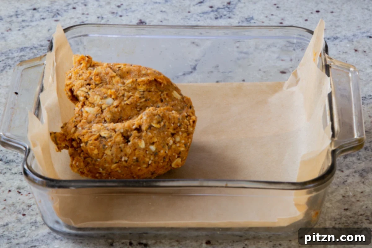 Doritos Nacho Crunch Bars 12 A ball of savory granola bar dough placed in a parchment-lined baking sheet