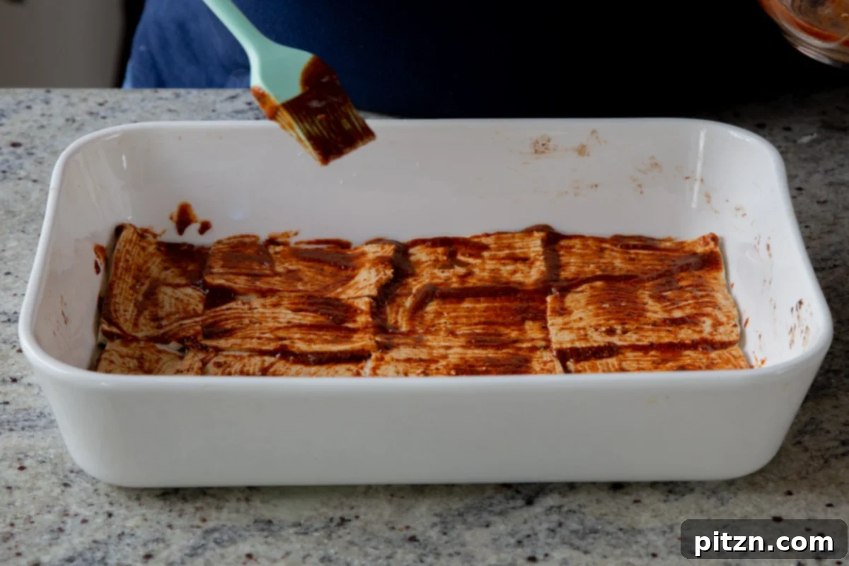Plant-Based Deli Club 11 Thin tofu deli slices, generously coated with marinade, neatly arranged in a baking pan and ready for the oven.