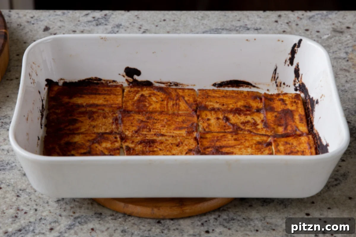 Plant-Based Deli Club 12 Golden-brown tofu deli slices, perfectly baked and slightly crispy, cooling in the pan after being removed from the oven.