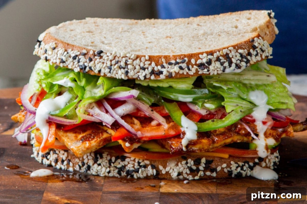 Plant-Based Deli Club 19 A completed vegan club sandwich, richly filled with layers of tofu deli meat and fresh vegetables, resting on a wooden cutting board before slicing.