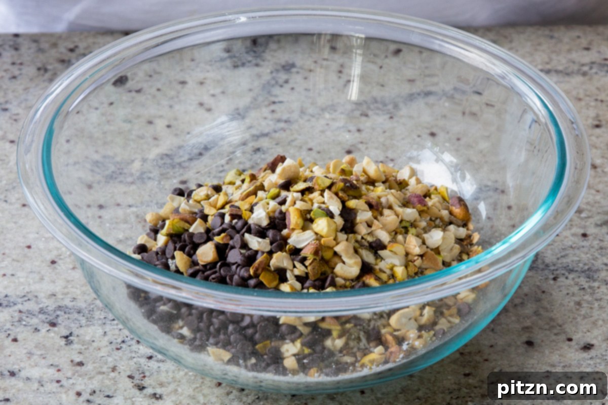 Perfectly Crisp Granola Bars 10 adding chocolate chips and chopped nuts to the bowl