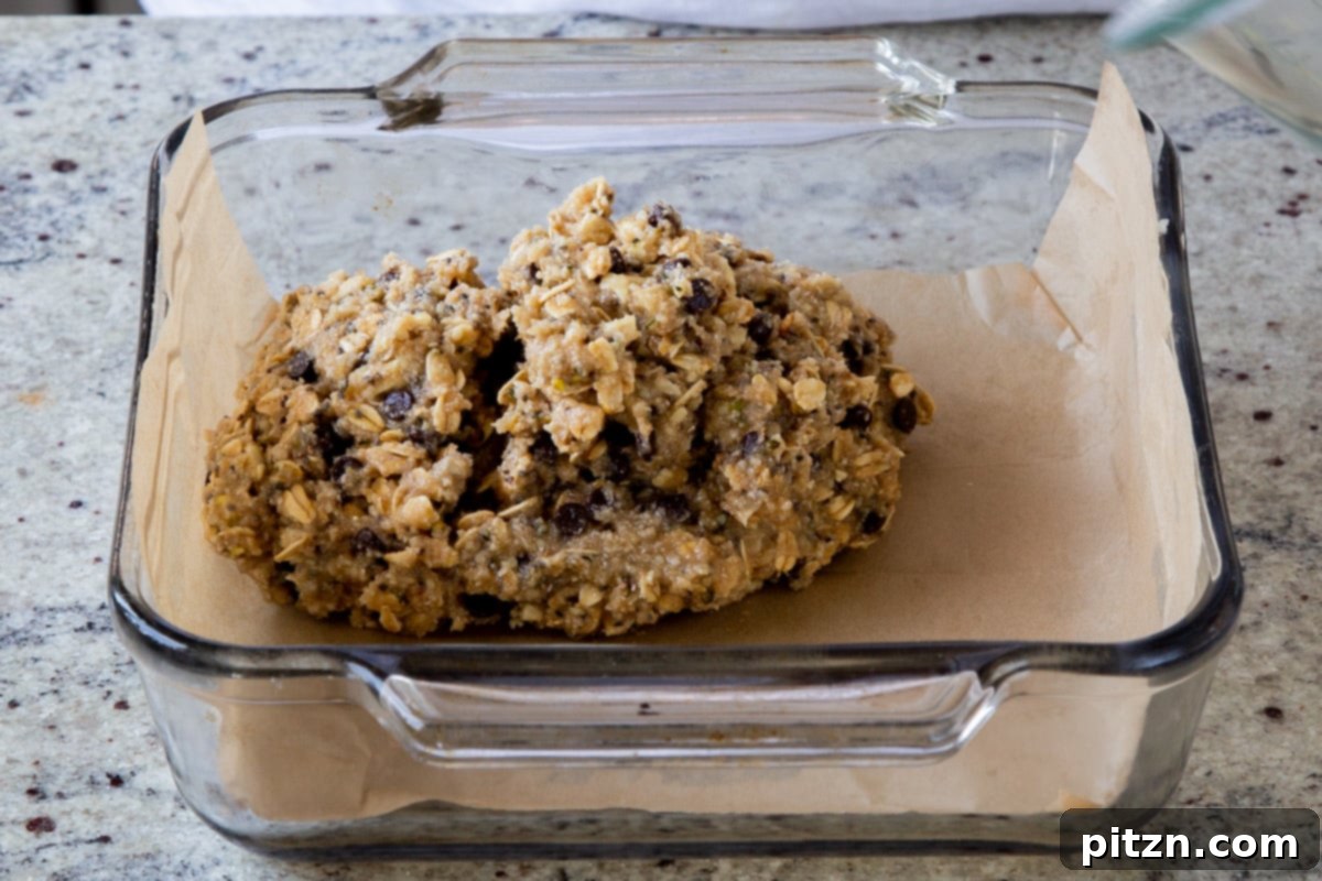 Perfectly Crisp Granola Bars 14 adding the granola bar dough to the baking pan