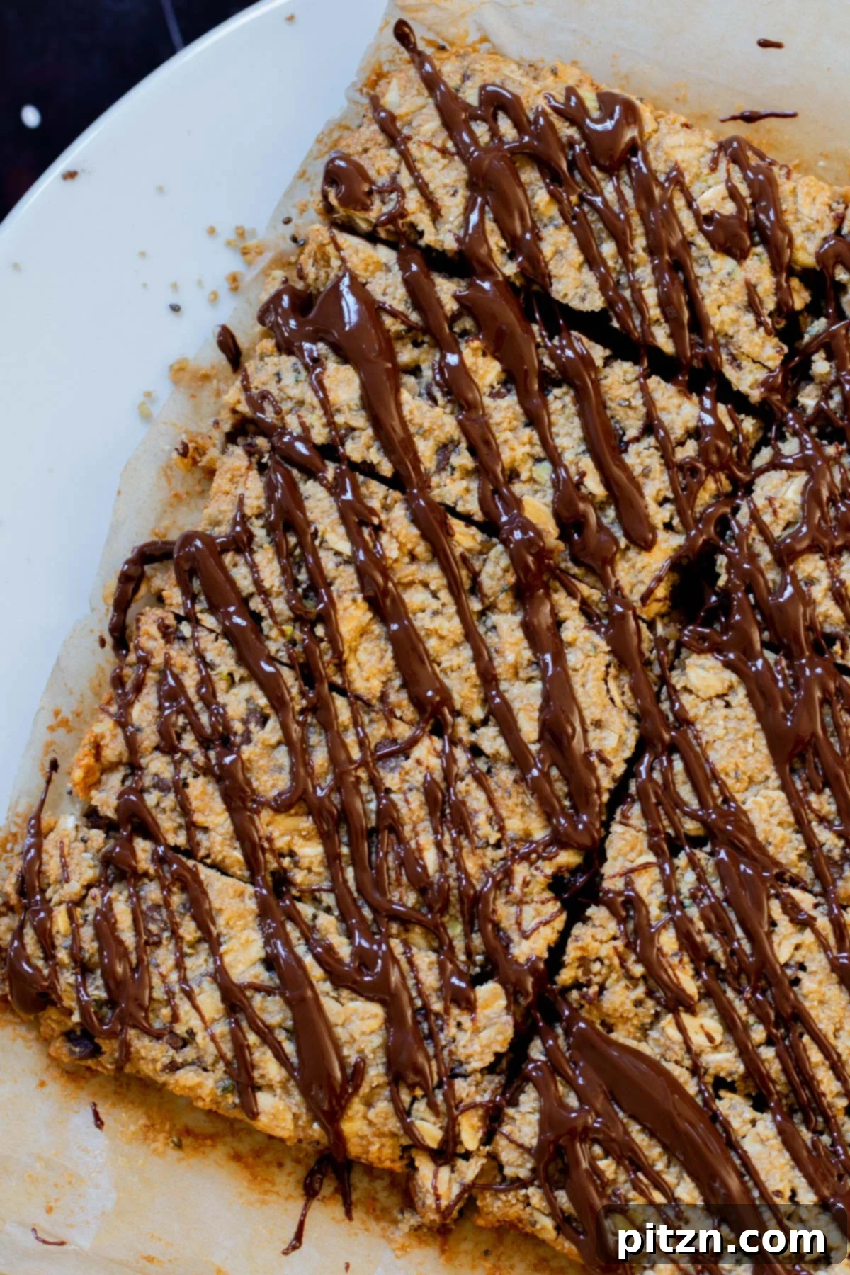 Perfectly Crisp Granola Bars 3 crunchy granola bars with chocolate topping on a white plate