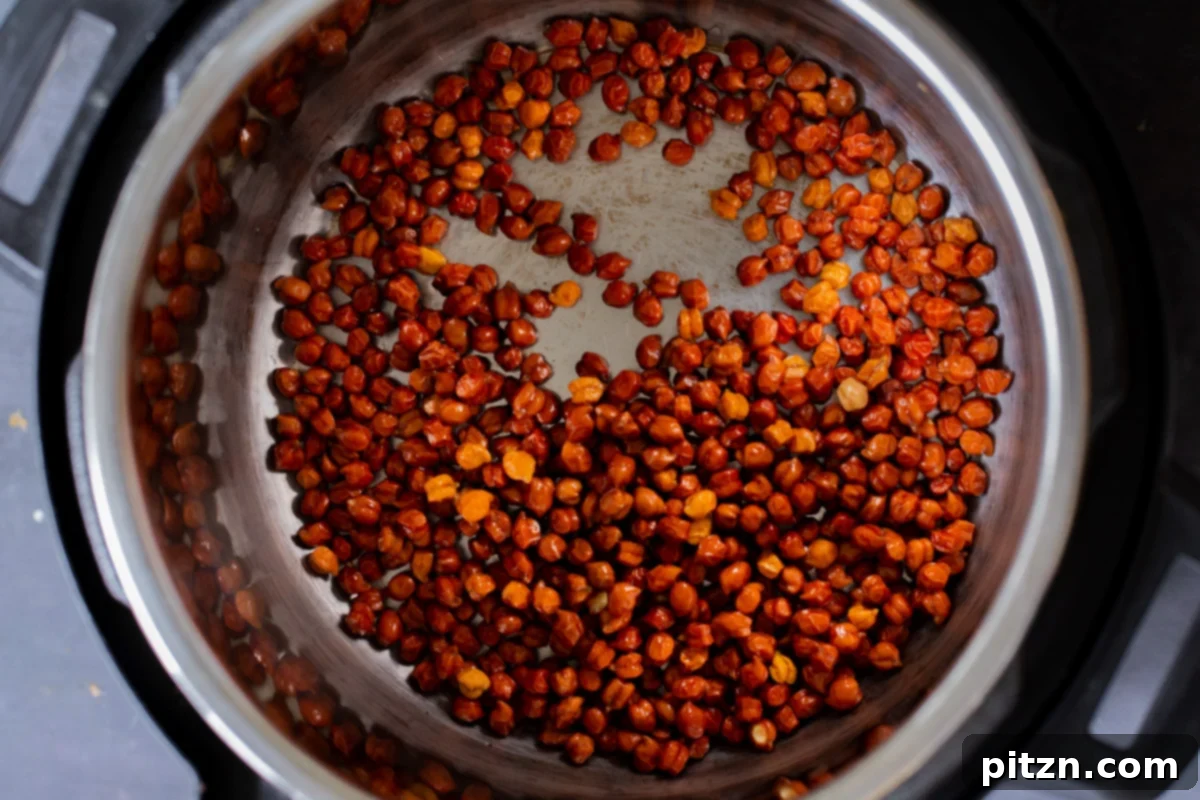 Soaked brown chickpeas submerged in water, ready for cooking in an Instant Pot, illustrating the initial preparation step.