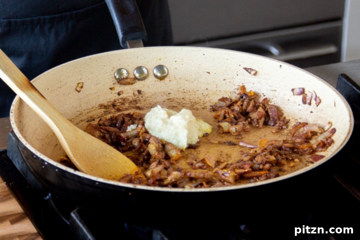 North Indian Restaurant Bhuna: A Vegetarian Curry Classic 11 adding ginger-garlic paste to the pan of cooked onions