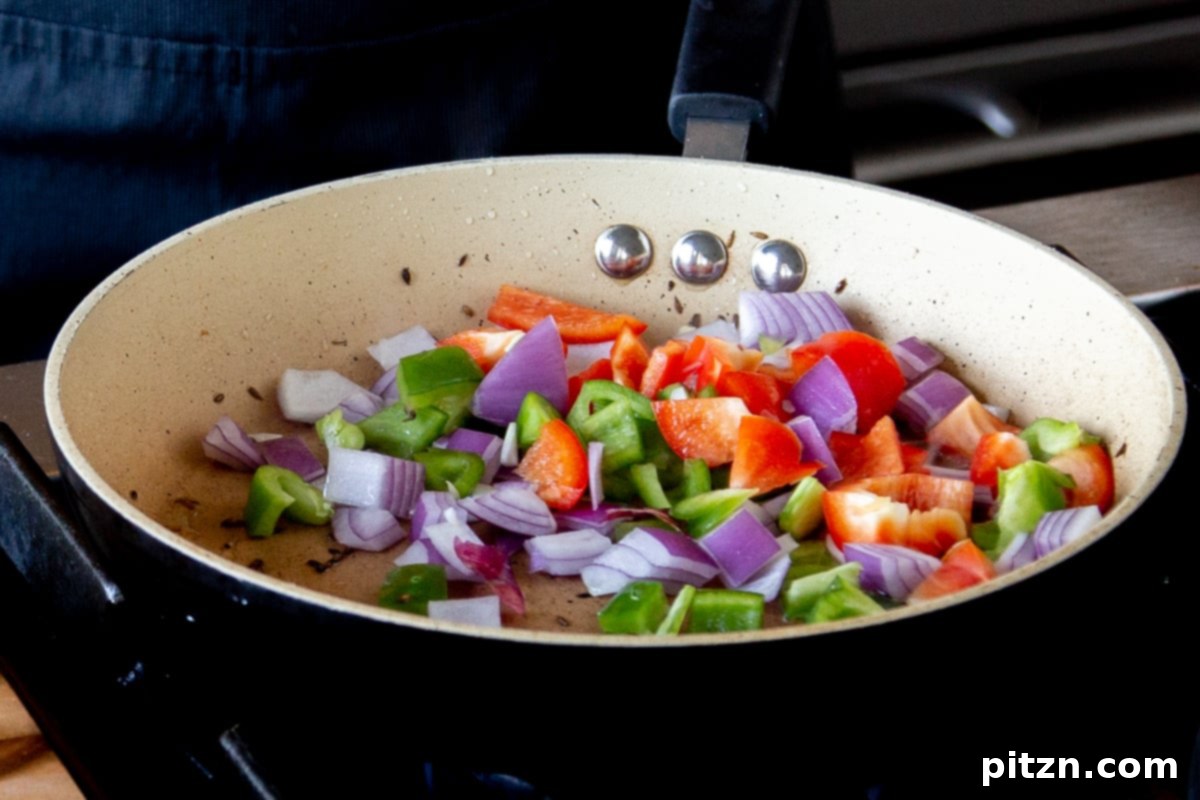 North Indian Restaurant Bhuna: A Vegetarian Curry Classic 16 adding bell pepper and onion to the pan with toasted spices for the topping