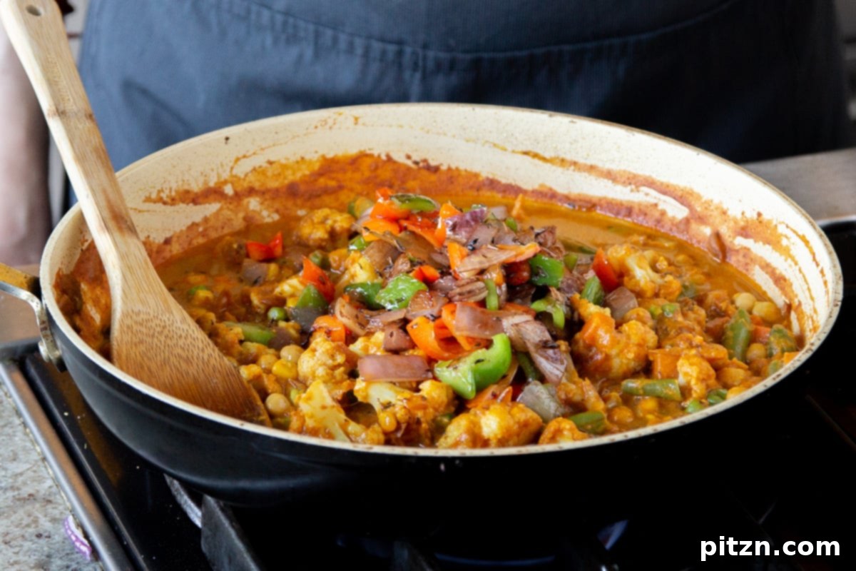 North Indian Restaurant Bhuna: A Vegetarian Curry Classic 18 adding the spiced oil topping to the vegetable bhuna mixture