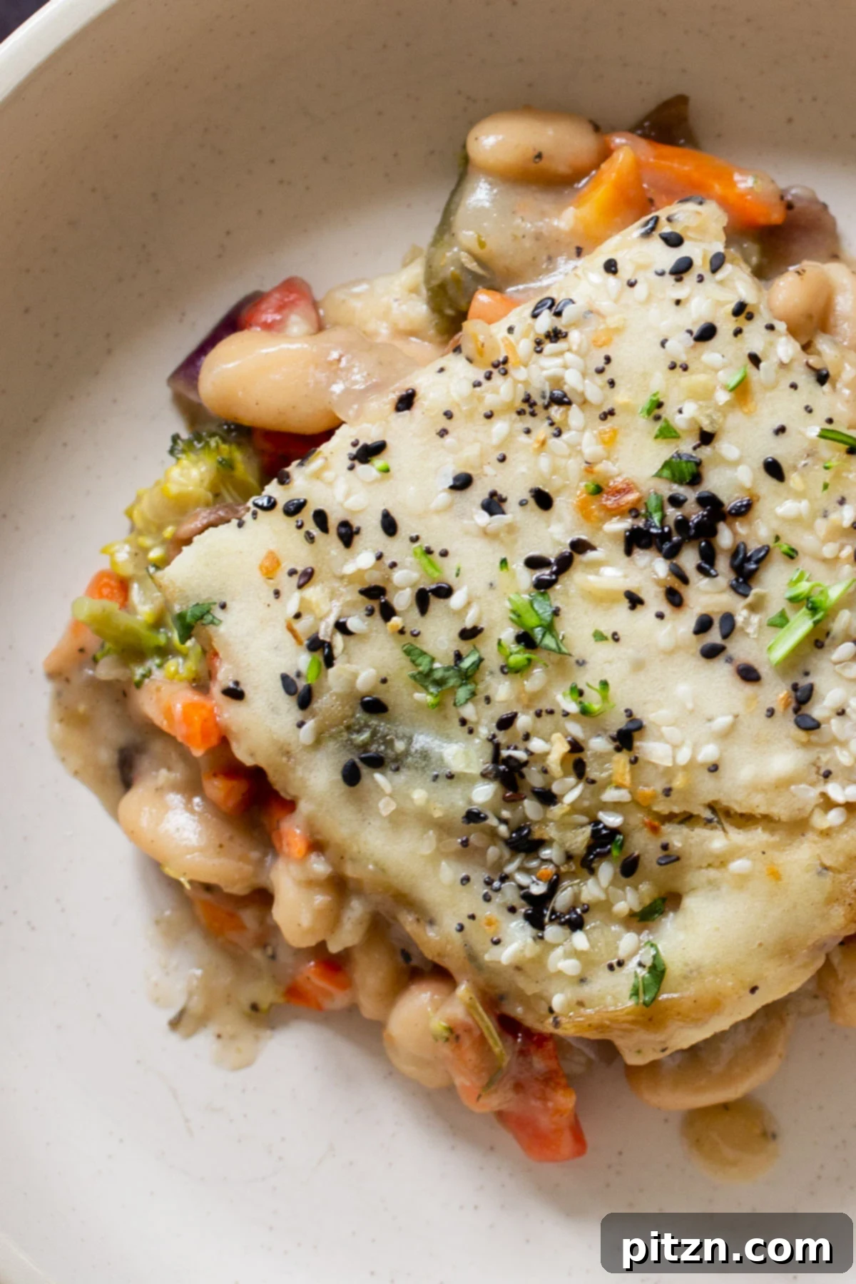 Everything Bagel Pot Pie Remix 2 Close-up of a serving of everything bagel pot pie on a plate, showcasing the rich fillings and crispy biscuit