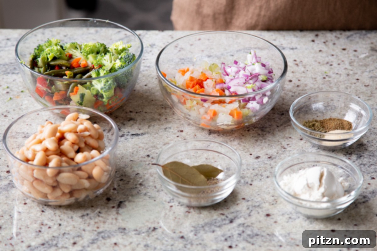 Everything Bagel Pot Pie Remix 7 Various chopped vegetables, beans, and seasonings displayed in bowls on a kitchen counter, ready for preparation