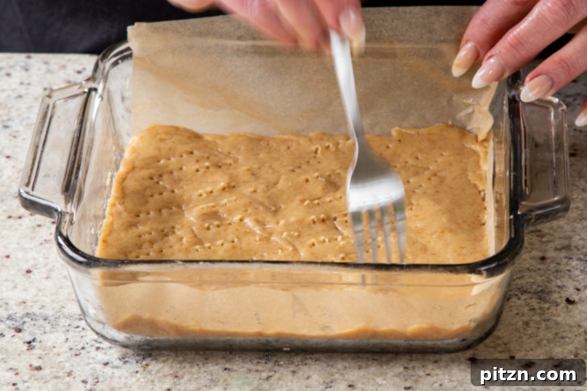 using a fork to pierce holes into the unbaked crust