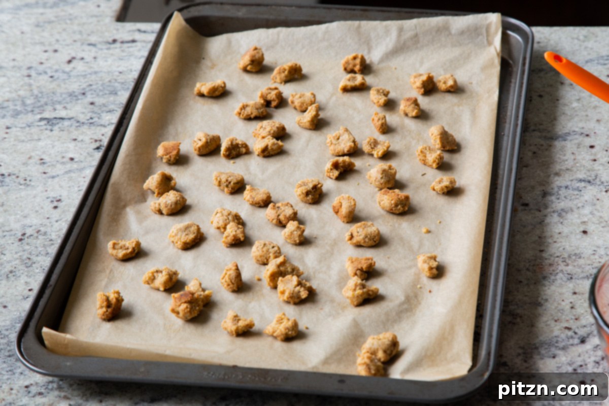 The golden brown and crispy almond flour croutons, freshly baked and cooled on the baking sheet, ready to add their satisfying crunch to the salad.