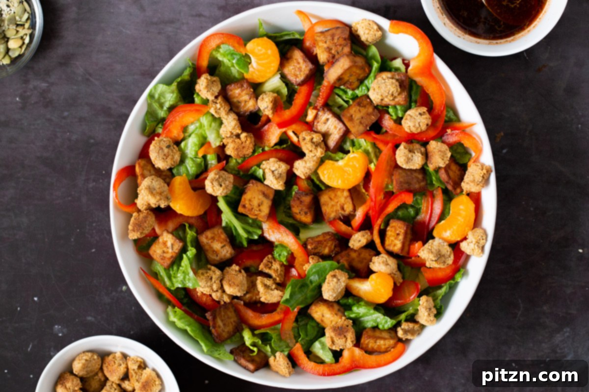 Crispy almond flour croutons being sprinkled over the assembled salad, adding a final, satisfying crunch and savory flavor.