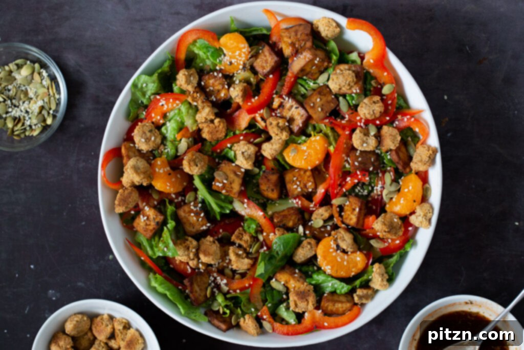A generous sprinkling of mixed seeds being added to the top of the vibrant summer salad, enhancing texture and nutritional value.