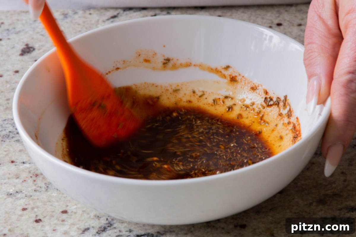 The dressing ingredients, now thoroughly mixed in the bowl, exhibiting a smooth, rich brown color, ready to infuse the tofu with smoky flavor.