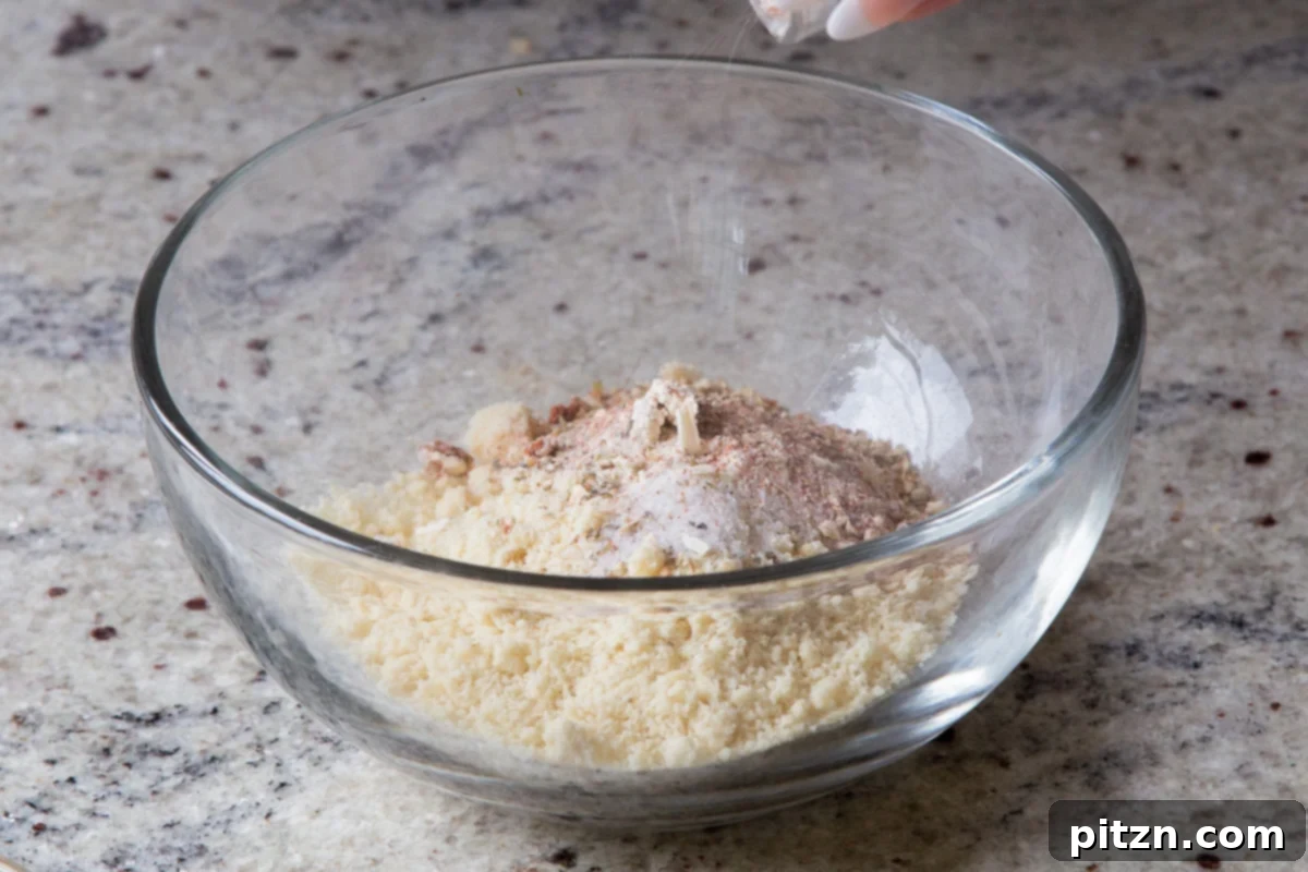 Dry ingredients for the almond flour croutons, including almond flour and various spices, resting in a mixing bowl before being combined with wet ingredients.