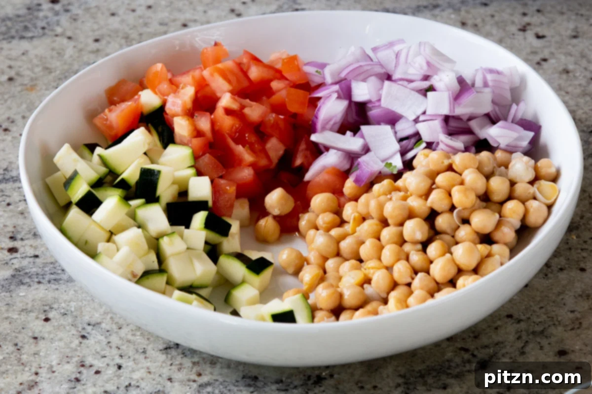 Fragrant Curry Leaf Mango Chickpea Zucchini Koshimbir 11 Finely chopped red onion being added to the salad bowl, providing a crisp and pungent element to the Koshimbir.